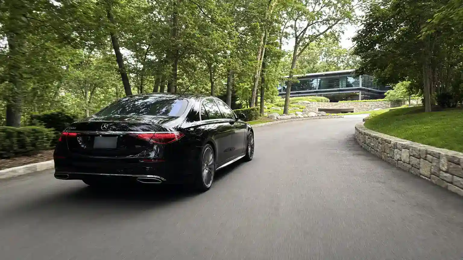 Black Mercedes sedan on a tree-lined Westchester parkway heading toward Harrison