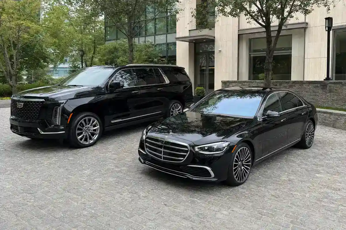 Late-model black Cadillac Escalade and Mercedes sedan of the Gotham Ride Westchester fleet
