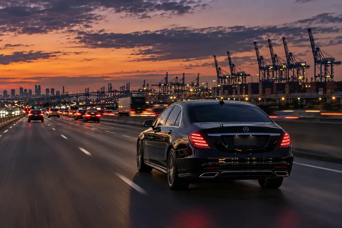 Black sedan on the interstate at dusk during a Connecticut to Newark airport car service trip