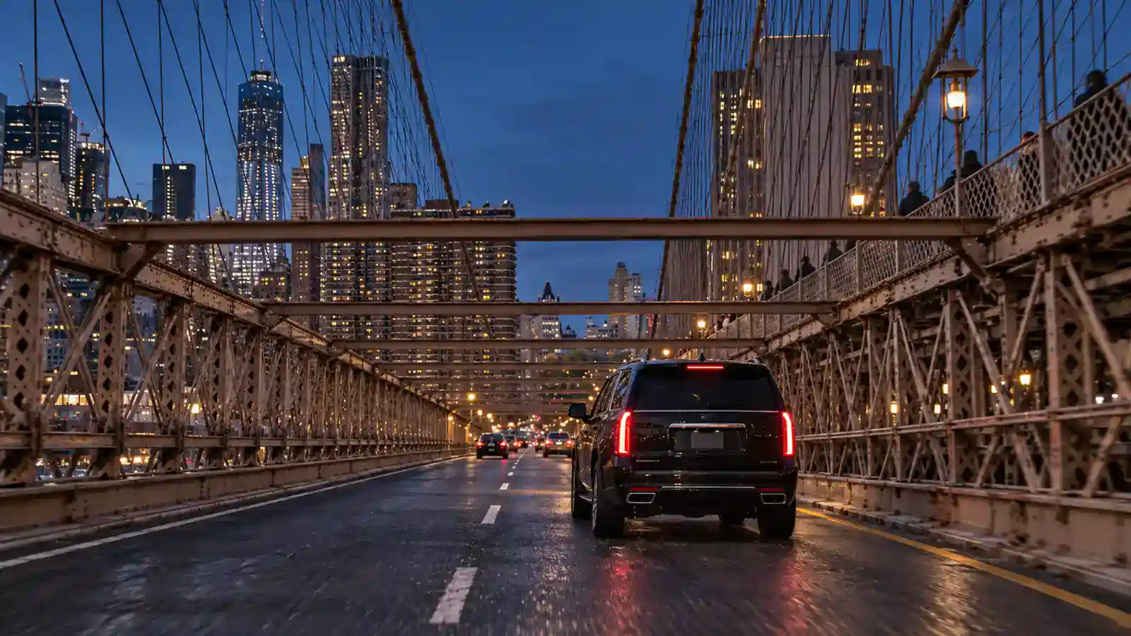 Black SUV crossing the Brooklyn Bridge at dusk